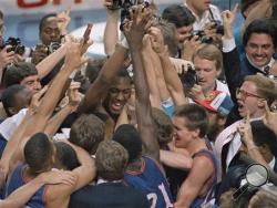 In this April 4, 1988, file photo Kansas' Danny Manning, facing camera, left of center, is mobbed by fans and teammates after he led his team to an 83-79 victory over Oklahoma in the championship game of the NCAA men's basketball Final Four in Kansas City, Mo. Led by Manning, Kansas won the tournament, proving most every expert wrong. That team became known as Danny and the Miracles. (AP Photo/Susan Ragan, File)