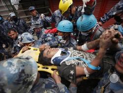Pemba Tamang is carried on a stretcher after being rescued by Nepalese policemen and U.S. rescue workers from a building that collapsed five days ago in Kathmandu, Nepal, Thursday, April 30, 2015. (AP Photo/Niranjan Shresta)