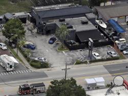 In this June 12, 2016 file photo, law enforcement officials work at the Pulse nightclub following a fatal shooting, in Orlando, Fla. Two government officials familiar with the Orlando shooting say FBI investigators have so far not turned up persuasive evidence that the gunman was pursuing gay relationships. (AP Photo/Chris O'Meara, File)