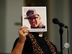 A photo of Simon Adrian Carrillo Fernandez is held up as the names of all those killed in the mass shooting at the Pulse nightclub are read aloud during an interfaith service at the First United Methodist Church of Orlando, Fla., Tuesday, June 14, 2016. A gunman killed dozens of people at a gay nightclub in Orlando on Sunday, making it the worst mass shooting in modern U.S. history. (Curtis Compton/Atlanta Journal-Constitution via AP) 