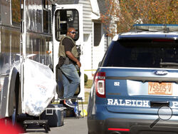 Police remain on the scene at Castle Pines Dr. and Sahalee Way following a shooting Thursday night in Raleigh, N.C., on Friday, Oct. 14, 2022. Police say a 15-year-old boy fatally shot at least two people in the streets of a neighborhood in North Carolina’s capital city, then fled toward a walking trail, where he opened fire, killing and wounding others. (AP Photo/Chris Seward)