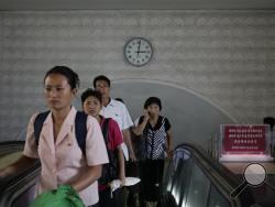 In this Sept. 1, 2014, photo, a clock hangs on the wall as North Koreans leave an underground train station in Pyongyang, North Korea. (AP Photo/Wong Maye-E, File)