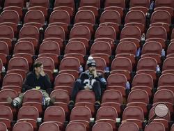 In this Sunday, Feb. 7, 2016, photo, Carolina Panthers fans sit in the stands after the NFL Super Bowl 50 football game where the Broncos won 24-10 in Santa Clara, Calif. According to observers of satellite tracking data, North Korea’s newest satellite Kwangmyongsong 4, which launched Sunday, passed almost right over the stadium just an hour after the Super Bowl ended. (AP Photo/Charlie Riedel)