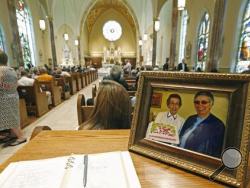 A photograph of Sister Margaret Held of the School Sisters of St. Francis, left, and Sister Paula Merrill, of the Sisters of Charity of Nazareth, is placed at the entrance to the Cathedral of St. Peter the Apostle, Monday, Aug. 29, 2016 in Jackson, Miss., where a memorial Mass was held for the two 68-year-old nuns, who were killed Thursday in their Durant, home. Hundreds of people filled the cathedral in Jackson on Monday to remember two nuns who spent decades helping the needy. (AP Photo/Rogelio V. Solis)