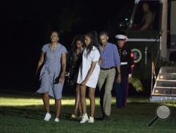 The Obamas return from vacation. (AP)
