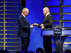 FILE - Coy Gibbs, right, presents the Hall of Fame ring to his father, NASCAR Hall of Fame inductee Joe Gibbs, during the induction ceremony in Charlotte, N.C., on Jan. 31, 2020. Coy, the vice chairman at Joe Gibbs Racing for his NFL and NASCAR Hall of Fame father, died Sunday morning, Nov. 6, 2022. He was 49. His death came just hour after his son Ty won the Xfinity Series championship. (AP Photo/Mike McCarn, File)