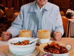 In this 2008 photo, chef Peng Chang-kuei poses for a photo as he is seated at a table in his restaurant Peng's Garden in Taipei, Tawain. The chef, who has been credited with inventing General Tso's chicken, a world-famous Chinese food staple that is not served in China, has died in Taiwan. He was 98. (Chiang-Zhong Su/United Daily News/World Journal via AP )