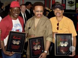 In this July 7, 2003 file photo, Philip Bailey, from left, Maurice White, and Ralph Johnson, of Earth Wind & Fire hold up the plaques from their induction at the Hollywood Rock Walk at a ceremony in Los Angeles. White, the founder and leader of Earth, Wind & Fire, died at home in Los Angeles, Wednesday, Feb. 3, 2016, said his brother, Verdine White. He was 74. (AP Photo/Matt Sayles, File)
