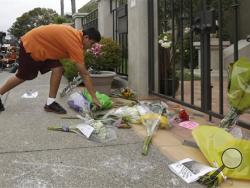 Brandon Antonio, 13, of San Rafael, leaves flowers outside of the home of Robin Williams in Tiburon, Calif., Tuesday, Aug. 12, 2014. Williams died Monday in an apparent suicide at his San Francisco Bay Area home, according to the sheriff's office in Marin County, north of San Francisco. (AP Photo/Jeff Chiu)