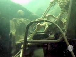 In this frame from video provided by the La Paz Sheriffs' Office, fake skeletons are strategically placed to appear as if they were sitting together with their lawn chairs bound to large rocks in the Colorado River near the Arizona and California border. 