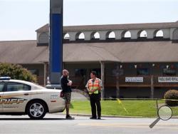 In this Thursday, Aug. 27, 2015 photo, Joe Brightwell talks with a Franklin County Sheriff's officer near the Bridgewater Plaza, where two WDBJ-TV journalists who were killed during an on-air broadcast Wednesday in Moneta, Va. (Heather Rousseau/The Roanoke Times via AP) 
