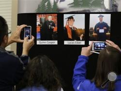 Reporters copy photographs of three of the victims of the mass shooting at Umpqua Community College that were displayed at a news conference, Friday, Oct. 2, 2015, in Roseburg, Ore. In the photos, from left, are Quinn Cooper, 18, Lucas Eibel,18, center, and Jason Johnson, 33. They were among those killed when Chris Harper Mercer walked into a class at the community college the day before and opened fire. (AP Photo/Rich Pedroncelli)