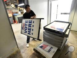 Dusty DeVinney places "vote here" signs onto a cart as he loads election materials at the Willowbank building Monday, April 25,2016, in Bellefonte, Pa., in preparation for Tuesday's primary election. (Nabil K. Mark/Centre Daily Times via AP)