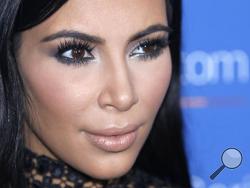 In this June 24, 2015, file photo, Kim Kardashian poses during a photo call at the Cannes Lions 2015. A spokeswoman for Kardashian West says she was held up at gunpoint inside her Paris hotel room Sunday, Oct. 2, 2016, by two armed masked men dressed as police officers. The representative said the reality TV star is "badly shaken but physically unharmed." She offered no other details. (AP Photo/Lionel Cironneau, File)