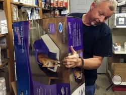 This Nov. 30, 2015, photo shows Bobby Hill, co-owner of Countryside Pet Supply in West Plains, Mo., packing a ScoopFree Automatic Litter Box for shipping. Sales of the litter boxes have gone up 400 percent in the last two years. Hill’s wife, Heather, says the box uses a disposable tray so you never have to touch the litter or the waste. It sells at the couple’s online store and at their store on eBay. (Heather Hill via AP)