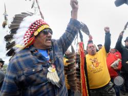 JR American Horse, left, raises his fist with others while leading a march to the Dakota Access Pipeline site in southern Morton County North Dakota. Several hundred protesters marched about a mile up Hwy 1806, Friday Sept. 9, 2016, from the protest camp to the area of the pipeline site where some archeological artifacts have been discovered. (Will Kincaid/The Bismarck Tribune via AP)