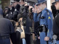 In this Feb. 13, 2015, photo Sgt. Robert Burke of the Maine State Police salutes along with other officers from local communities as Canine Officer Shane Stephenson of the South Portland Police Department carries Sultan, a retired police dog into the Yarmouth Veterinary Center where he was euthanized in Yarmouth, Maine. (AP Photo/Portland Press Herald, Shawn Patrick Ouellette)