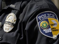 FILE - In this July 11, 2016 file photo, the badge of Dallas Area Rapid Transit police officer Evan Moses is shown with a black band over it, in Dallas. Moses was visiting the makeshift memorial in front of Dallas police department headquarters. The number of police killed in the line of duty rose sharply in 2016, driven by shootings of police around the country, most notably ambushes in Dallas and Baton Rouge, Louisiana. From Jan. 1 through Wednesday, 135 officers lost their lives. Some died in traffic acc