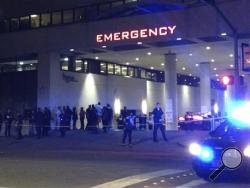 Police and others gather at the emergency entrance to Baylor Medical Center in Dallas, where several police officers were taken after shootings Thursday, July 7, 2016.. (AP Photo/Emily Schmall)