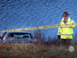 A police officer investigates the scene where six people were rescued after their car went into a holding pond near a highway exit ramp Thursday in St. Louis Park, Minn. The children's conditions weren't immediately known, although a St. Louis Park city spokeswoman said they were unresponsive when they were pulled from the car. The driver of the car, a 23-year-old woman, made it out on her own as the car sank. She was in stable condition. (AP Photo/The Star Tribune, Elizabeth Flores)