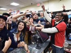 7-Eleven store clerk M. Faroqui celebrates with customers after learning the store sold a winning Powerball ticket on Wednesday, Jan. 13, 2016 in Chino Hills, Calif. One winning ticket was sold at the store located in suburban Los Angeles said Alex Traverso, a spokesman for California lottery. The identity of the winner is not yet known. (Will Lester/The Sun via AP)