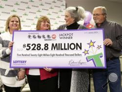 Rebecca Hargrove, second from right, president and CEO of the Tennessee Lottery, presents a ceremonial check to John Robinson, right; his wife, Lisa, second from left; and their daughter, Tiffany, left; after the Robinson's winning Powerball ticket was authenticated at the Tennessee Lottery headquarters Friday, Jan. 15, 2016, in Nashville, Tenn. The ticket was one of three winning tickets in the $1.6 billion jackpot drawing. (AP Photo/Mark Humphrey)
