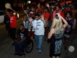Protestors push Leon Ford while shouting "Don't shoot!" and making the now familiar hands up gesture seen in protests in Ferguson, Missouri, while marching in Highland Park. Ford was shot by Pittsburgh police during a traffic stop on Nov. 11, 2012. (AP)