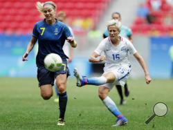 In this Friday, Aug. 12, 2016, file photo, United States' Megan Rapinoe, right, kicks the ball past Sweden's Lisa Dahlkvist during a quarterfinal match of the women's Olympic soccer tournament in Brasilia. Rapinoe knelt during the national anthem Sunday, Sept. 4, before the Seattle Reign's game against the Chicago Red Stars "in a little nod" to NFL quarterback Colin Kaepernick. (AP Photo/Eraldo Peres, File)