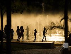 In this June 29, 2015, file photo, children play as they cool down in a fountain beside the Manzanares river in Madrid, Spain. AP Photo/Andres Kudacki, File)