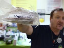  Mike Fitzgerald holds a storage bag of cannabis-infused cookies marked "medicated" during a cooking class at the New England Grass Roots Institute in Quincy, Mass. For many sick people, especially those with cancer, smoking marijuana is not a safe option, and some edibles can deliver a longer-lasting therapeutic dose that doesn’t give them a buzz. (AP Photo/Michael Dwyer)