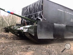 In this photo taken from video released by the Russian Defense Ministry Press Service on Tuesday, Nov. 26, 2024, a Russian T-80 tank rolls in Donetsk region in Ukraine. (Russian Defense Ministry Press Service via AP)