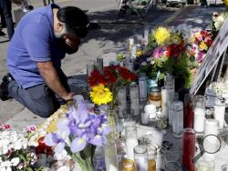 ose Cardoso pays his respects at a makeshift memorial in front of the IV Deli Mart, where part of Friday night's mass shooting took place by a drive-by shooter Sunday, May 25, 2014, in the Isla Vista area near Goleta, Calif. Sheriff's officials said Elliot Rodger, 22, went on a rampage near the University of California, Santa Barbara, stabbing three people to death at his apartment before shooting and killing three more in a crime spree through a nearby neighborhood. (AP Photo/Chris Carlson)