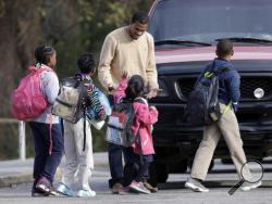 Students walk to their cars for their rides home outside Woodmore Elementary School on Tuesday, Nov. 22, 2016, in Chattanooga, Tenn. The school bus driven by Johnthony Walker, 24, crashed while transporting children home from the school Monday, killing at least five students. Walker was arrested Monday and charged with five counts of vehicular homicide including reckless driving and reckless endangerment, police said. (AP Photo/Mark Humphrey)
