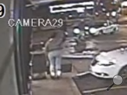 Although pixelated, this screenshot from surveillance footage appears to show an 18-year-old suspect holding out what police said was a 9mm handgun in an officer's direction before the officer fatally shot the the teen. (Video from the St. Louis County Police)