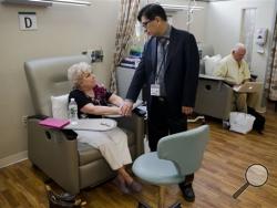 Judith Bernstein meets with Dr. Henry Fung at the Fox Chase Cancer Center in Philadelphia on Tuesday, Aug. 4, 2015. Her husband, Arnold, is at right. Bernstein has had eight different types of cancer over the last two decades, all treated successfully. (AP Photo/Matt Rourke)