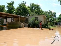 Irene Martinez, who lives near the Brazos River, leaves her flooded home Sunday, May 29, 2016, in Richmond, Texas. Martinez lives there with her two sons, and they are evacuating because the river is exprected to rise another several feet. (Jon Shapley/Houston Chronicle via AP)