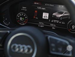 The dashboard of an Audi A4 is seen during a demonstration of Audi's vehicle-to-infrastructure technology Tuesday, Dec. 6, 2016, in Las Vegas. The technology allows vehicles to "read" red lights ahead and tell the driver how long it'll be before the signal turns green. For the driver, the system puts a traffic signal icon on the dashboard telling how many seconds the light will remain red. (AP Photo/John Locher)