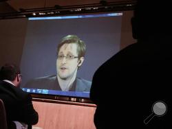  In this Feb. 17, 2016, file photo, former National Security Agency contractor Edward Snowden, center, speaks via video conference to people in the Johns Hopkins University auditorium in Baltimore. The Intercept, an online news site whose founding editors were the first to publish documents leaked by Snowden, released on Monday, May 16, the first batch of nine years' worth of the newsletters, which offer a behind-the-scenes glimpse into the NSA’s work. (AP Photo/Juliet Linderman, File)