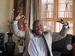 Thamsanqa Jantjie gesticulates at his home during an interview with the Associated Press in Johannesburg, South Africa,Thursday, Dec. 12, 2013. Jantjie, the man accused of faking sign interpretation next to world leaders at Nelson Mandela's memorial, told a local newspaper that he was hallucinating and hearing voices. (AP Photo/Tsvangirayi Mukwazhi)