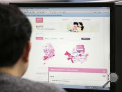 A journalist watches a screen showing a press release from the South Korean Ministry of the Interior about the birth map showing the number of women in childbearing age at his office in Seoul, South Korea, Friday, Dec. 30, 2016. South Korea's government closed its website that drew fury for showing the number of women in childbearing age by each city district and region. The letters at left top read "Birth Map." (AP Photo/Ahn Young-joon)