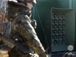 A South Korean soldier stands near the loudspeakers near the border area between South Korea and North Korea in Yeoncheon, South Korea, Friday, Jan. 8, 2016. South Korea responded to North Korea's nuclear test with broadcasts of anti-Pyongyang propaganda across the rival's tense border Friday, believed to be the birthday of North Korean leader Kim Jong Un. (Lim Tae-hoon/Newsis via AP)