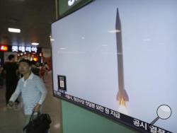A man passes by a TV news program with file footage of a North Korean rocket launch at the Seoul Railway Station in Seoul, South Korea, Wednesday, Aug. 3, 2016. North Korea fired a ballistic missile into the sea on Wednesday South Korea's military said, the fourth reported weapons launch the North has carried out in about two weeks. (AP Photo/Ahn Young-joon)