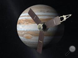 This artist's rendering provided by NASA and JPL-Caltech shows the Juno spacecraft above the planet Jupiter. Five years after its launch from Earth, Juno is scheduled to go into orbit around the gas giant on Monday, July 4, 2016. (NASA/JPL-Caltech via AP)