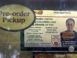 A photo of Subway restaurant spokesman Jared Fogle is seen on a menu board hanging inside one of its locations Tuesday, July 7, 2015, in St. Louis. FBI agents and Indiana State Police raided the home of Fogle on Tuesday, removing electronics from the property and searching the house with a police dog. (AP Photo/Jeff Roberson)