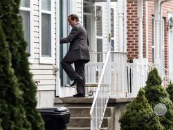 A law enforcement official enters a home in Harrisburg, Pa., Tuesday afternoon. Dec. 17, 2015, where Jalil Ibn Ameer Aziz, 19, was arrested on charges he attempted to provide support to the Islamic State group. (James Robinson/PennLive.com via AP)