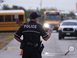 Southside Independent School District police officer Ruben Cardenas keeps watch as students arrive at Freedom Elementary School, Wednesday, Aug. 23, 2023, in San Antonio. Most Texas school districts say they are unable to comply with a new law requiring armed officers on every campus. The mandate was one of Republican lawmakers' biggest acts following the Uvalde school shooting in 2022 that killed 19 children and two teachers. (AP Photo/Eric Gay)