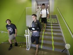 Utah Valley University students walks along the bright green lanes painted on the stairs to the gym Thursday, June 18, 2015, at Utah Valley University, in Orem, Utah. (AP Photo/Rick Bowmer)