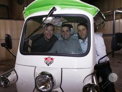 In this photo taken Friday, Feb. 27, 2015, Colin Sommers, left, director of engineering of eTuk USA, joins Walid Mourtada, center, chief executive officer, and Michael Fox, in one of the electric Tuk-Tuk models that the trio import and sell domestically in the firm's manufacturing plant in Denver. (AP Photo/David Zalubowski)