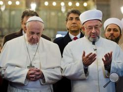 In this photo provided by Vatican newspaper L'Osservatore Romano, Pope Francis joins Grand Mufti of Istanbul, Rahmi Yaran praying in the Sultan Ahmet mosque in Istanbul, Turkey, Saturday, Nov. 29, 2014. (AP Photo/L'Osservatore Romano)
