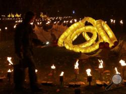 In this Nov. 22, 2016, file photo, a representative poses for a photograph beside the "Five Golden Rings" section of a "Fire Garden" display, on the eve of the public opening of the "Christmas at Kew" festival at the Royal Botanic Gardens, Kew, in London. The slow recovery of the U.S. economy is keeping the cost of gifts listed in the song "The Twelve Days of Christmas" from spiraling out of control, according to Pittsburgh-based PNC Financial Services Group's 33nd annual "PNC Wealth Management Christmas Pr